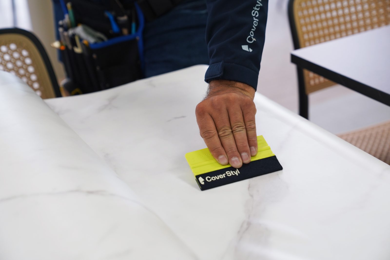 Espátula asentando lámina de mármol sobre una mesa