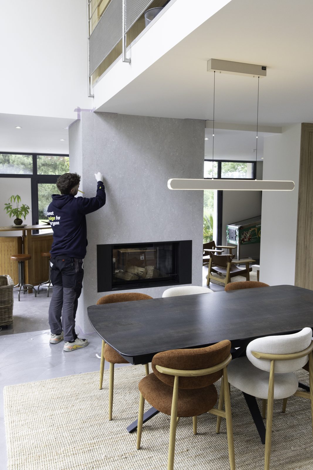 Comedor con la columna de la chimenea forrada en lámina de piedra gris